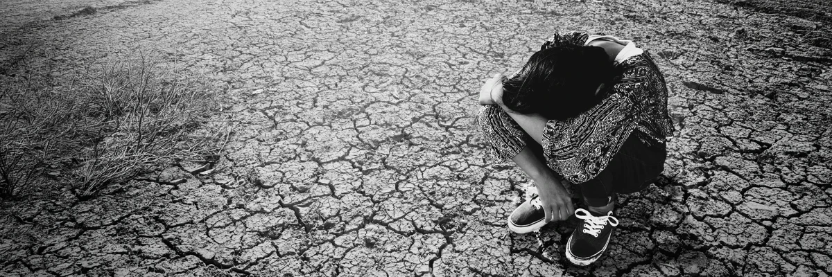 woman struggling with depression sitting on broken ground