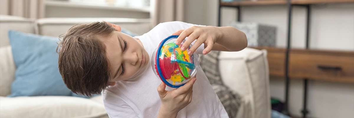 young boy playing with toy focusing with adhd